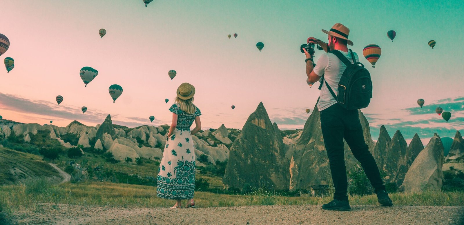 man taking photo of hot air balloons